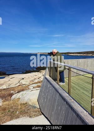 Machen Sie ein Foto des Leuchtturms von der hölzernen Aussichtsplattform in Peggy's Cove, Nova Scotia, Kanada Stockfoto