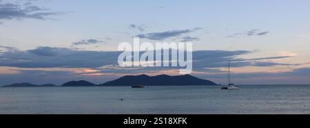 Katamaran und Ko Khlum, kleine Insel bei Sonnenuntergang, Blick vom Strand Klong Kloi, Ko Chang, Thailand. Stockfoto