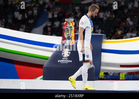 Peking, Deutschland. Juli 2024. Harry Kane aus England mit seiner Silbermedaille geht an der Trophäe während der Verleihung nach dem Endspiel der UEFA Euro 2024 zwischen England und Spanien am 14. Juli 2024 in Berlin vorbei. Quelle: Xiao Yijiu/Xinhua/Alamy Live News Stockfoto