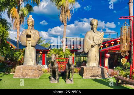 Statuen chinesischer Weisen, Pferdewagen und Palmen vor einem chinesischen Restaurant in Khao Kho, Provinz Phetchabun, Zentral-Norden Thailands Stockfoto