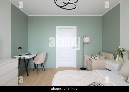 Ein modernes, minimalistisches Schlafzimmer mit Wänden mit sanften grünen Akzenten und schicker Einrichtung Stockfoto
