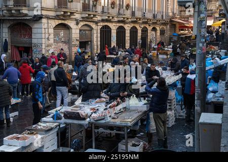 Catania, Italien - 30. Dezember 2024: Lebendige Szene auf dem historischen Fischmarkt in Catania, Sizilien - Händler, Kunden und Stände für frische Meeresfrüchte. Ein lebendiger Stockfoto