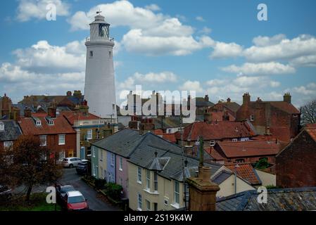 Southwold, Suffolk, England, Großbritannien - aus der Vogelperspektive auf den Leuchtturm und die umliegenden Cottages mit Dächern im Stadtzentrum vor einem hellblauen Himmel Stockfoto