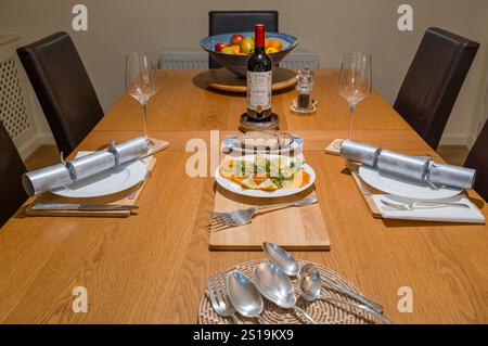 Esstisch für Weihnachtsessen mit Weihnachtskräckern und Vorspeise mit Räucherlachs, UK Stockfoto