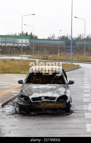 Verbrannter Pkw, der auf der Straße steht. Fahrzeug mit weitgehend ausgebranntem Innenraum. Stockfoto