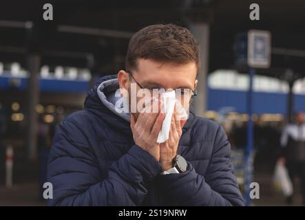 Ein Typ mit einer Erkältung und einer laufenden Nase Stockfoto