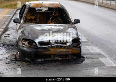 Verbrannter Pkw, der auf der Straße steht. Fahrzeug mit weitgehend ausgebranntem Innenraum. Stockfoto