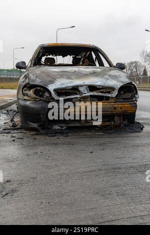 Verbrannter Pkw, der auf der Straße steht. Fahrzeug mit weitgehend ausgebranntem Innenraum. Stockfoto
