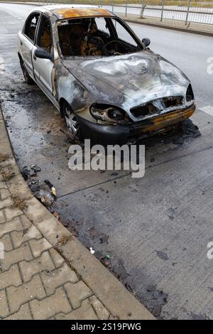 Verbrannter Pkw, der auf der Straße steht. Fahrzeug mit weitgehend ausgebranntem Innenraum. Stockfoto