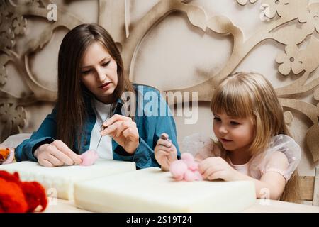 Mutter und Tochter basteln gemeinsam in einer gemütlichen Werkstatt am Nachmittag Stockfoto