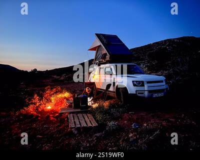 Camping und Lagerfeuer mit einem Geländewagen und Dachzelt in der abenteuerlichen Wildnis Stockfoto