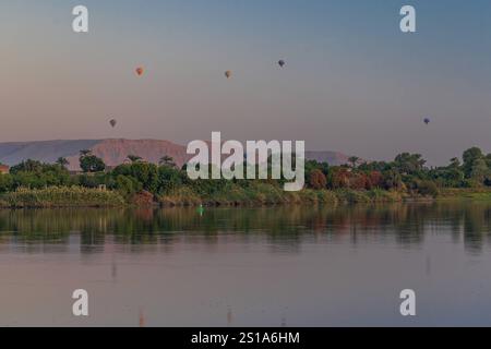 Ein faszinierender Blick auf die lebendigen Heißluftballons, die bei Sonnenaufgang über Luxor, Ägypten, schweben. Ein faszinierender Blick auf die Wüste von Luxor in der Nähe des Tals der Könige wi Stockfoto