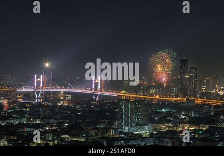 Bangkok, Thailand 31. Dez 2024 - Nachtansicht auf Wolkenkratzer mit farbenfrohem Feuerwerk erleuchten den Himmel über der Thotsamarachan-Brücke (Rama IX-Brücke) über C Stockfoto