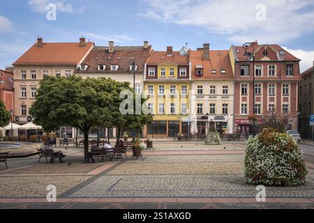 Besucher genießen an einem sonnigen Tag in Polen Freizeit auf Walbrzychs malerischem Platz mit farbenfrohen Gebäuden und üppigen Bäumen Stockfoto