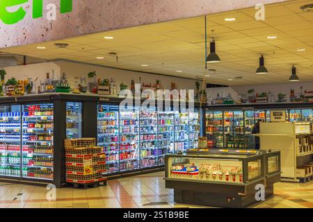 Gekühlte Vitrinen im Supermarkt gefüllt mit Getränken, Milchprodukten und Tiefkühlwaren. Stockfoto