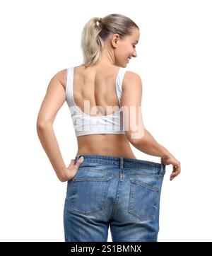 Gewichtsverlust. Glückliche Frau, die große Jeans auf weißem Hintergrund trägt Stockfoto