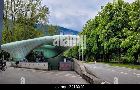 Blick auf die Hungerburgbahn Congress Station - Hybrid-Standseilbahn in Innsbruck. Im Hintergrund - wolkenbedeckte Gipfel der Alpen und blühend Stockfoto