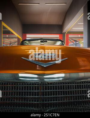 Balikpapan, Indonesien - 18. Dezember 2024. Nahaufnahme der Vorderseite eines Oldtimer 1958 Chevrolet Impala orange mit Chromdetails Stockfoto