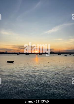 Halten Sie den Moment fest, halten Sie die Geschichte fest... Sonnenuntergänge und Bootssilhouetten, eine auffällige Kombination Stockfoto