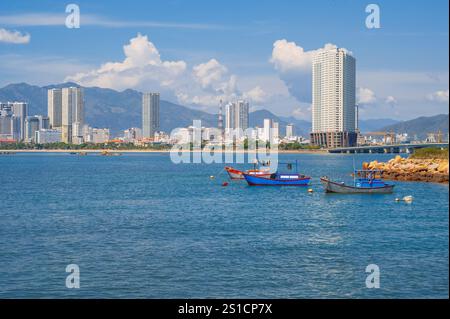 Blick vom Meer der Fischerboote und der vietnamesischen Stadt Nha Trang an einem sonnigen bewölkten Tag. Stockfoto