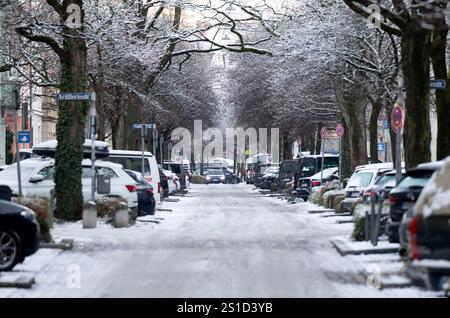 München, Deutschland. Januar 2025. Ein Auto fährt über eine schneebedeckte Straße im Stadtzentrum. Quelle: Sven Hoppe/dpa/Alamy Live News Stockfoto