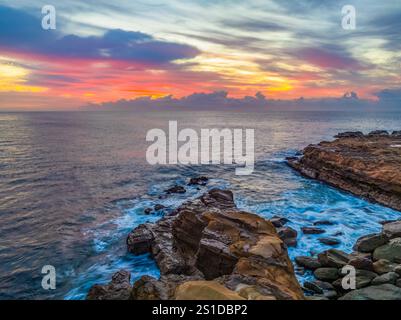 Das Zusammenspiel von Nebel und hohen Wolken verleiht dieser Küstensonnenaufgangsszene am Avoca Beach an der Central Coast von New South Wales, Au, eine zauberhafte Note Stockfoto