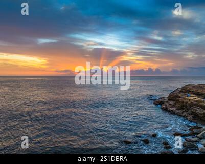 Das Zusammenspiel von Nebel und hohen Wolken verleiht dieser Küstensonnenaufgangsszene am Avoca Beach an der Central Coast von New South Wales, Au, eine zauberhafte Note Stockfoto