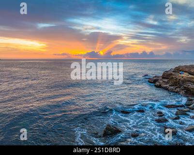 Das Zusammenspiel von Nebel und hohen Wolken verleiht dieser Küstensonnenaufgangsszene am Avoca Beach an der Central Coast von New South Wales, Au, eine zauberhafte Note Stockfoto