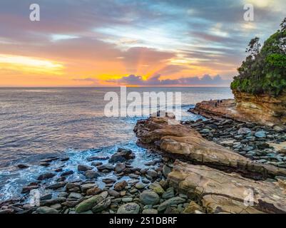 Das Zusammenspiel von Nebel und hohen Wolken verleiht dieser Küstensonnenaufgangsszene am Avoca Beach an der Central Coast von New South Wales, Au, eine zauberhafte Note Stockfoto