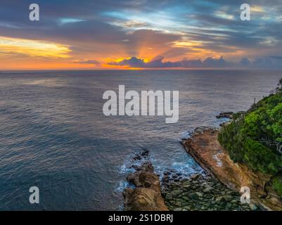 Das Zusammenspiel von Nebel und hohen Wolken verleiht dieser Küstensonnenaufgangsszene am Avoca Beach an der Central Coast von New South Wales, Au, eine zauberhafte Note Stockfoto