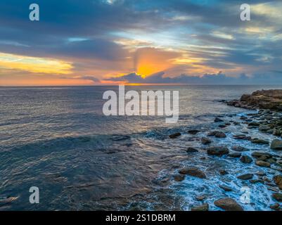 Das Zusammenspiel von Nebel und hohen Wolken verleiht dieser Küstensonnenaufgangsszene am Avoca Beach an der Central Coast von New South Wales, Au, eine zauberhafte Note Stockfoto