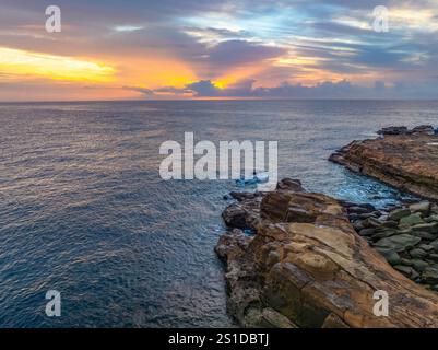 Das Zusammenspiel von Nebel und hohen Wolken verleiht dieser Küstensonnenaufgangsszene am Avoca Beach an der Central Coast von New South Wales, Au, eine zauberhafte Note Stockfoto