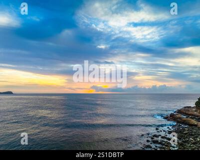 Das Zusammenspiel von Nebel und hohen Wolken verleiht dieser Küstensonnenaufgangsszene am Avoca Beach an der Central Coast von New South Wales, Au, eine zauberhafte Note Stockfoto