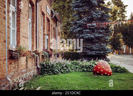 Viljandi Stadtblick auf die Straße in Estland im Sommer. Blumenbeete und große rote Erdbeerstatue. Stockfoto