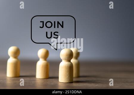 Holzfiguren stehen zusammen mit einer Sprechblase über ihnen, die sagt: „Mitmachen“. Zusammenarbeit, Community-Konzept. Stockfoto
