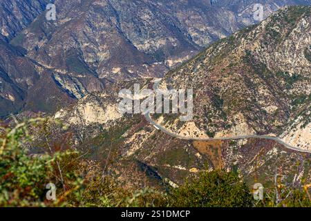 Blick auf eine kurvige Straße, die durch raues Gelände in Südkaliforniens bergiger Landschaft führt. Stockfoto