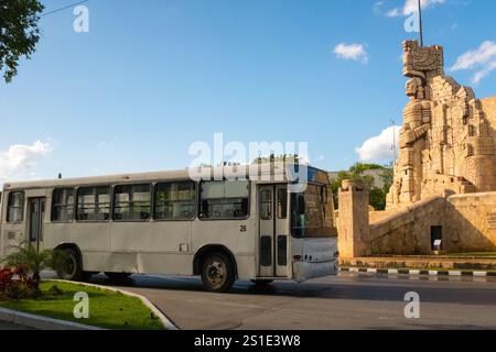 Bus vor dem Vaterlanddenkmal (1956) des kolumbianischen Bildhauers Romulo Rozo Pena auf der Avenue Paseo de Montejo, Merida, Mexiko Stockfoto