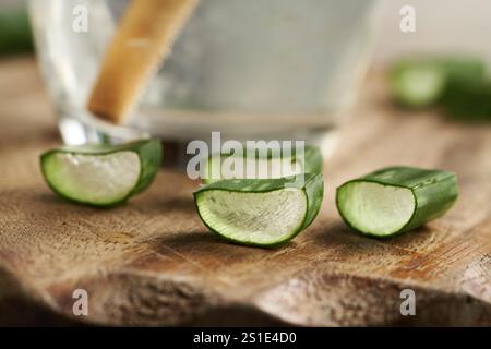 Geschnittenes Aloe Vera-Blatt und ein Glas Saft mit Bambusstroh Stockfoto