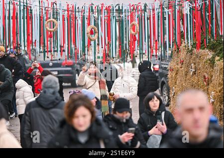 LVIV, UKRAINE - 29. DEZEMBER 2024 - Menschen laufen unter Bändern mit Glocken während des Bazaar der Guten Wohltätigkeitsveranstaltung zur Unterstützung streunender Tiere in Lviv, Westukraine. Stockfoto