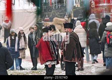 LVIV, UKRAINE - 29. DEZEMBER 2024 - Caroller aus Kryworivnia, Iwano-Frankiwsk, die traditionelle Kleidung der Hutsul tragen, nehmen an der Wohltätigkeitsveranstaltung „Basar der Guten“ Teil, die zur Unterstützung streunender Tiere in Lviv, Westukraine stattfindet. Stockfoto