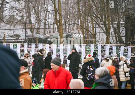 LEMBERG, UKRAINE - 29. DEZEMBER 2024 - Menschen gehen an den Fotos von streunenden Tieren vorbei, die während des Basars der guten Wohltätigkeitsveranstaltung in Lemberg, Westukraine gezeigt wurden. Stockfoto