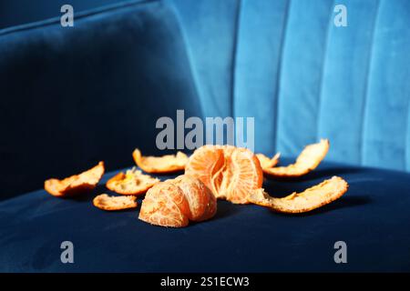 Frisch geschälte Mandarine auf dunkelblauem Sessel Stockfoto