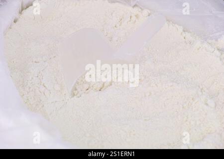 Nahaufnahme eines Messlöffels in einer Packung mit Mehl. Stockfoto