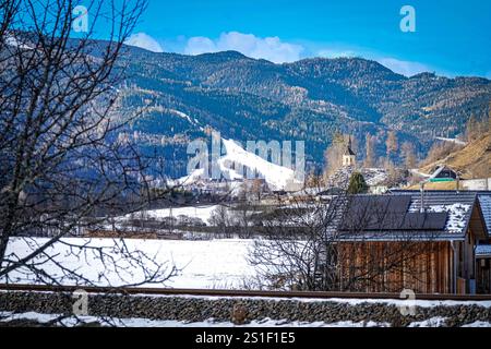 Murau-West, Steiermark, Österreich, Alpenregion Neues Bauprojekt von Almdorfbau, Luxus Chalets, Nähe zur Skipiste Kreischberg, Wintersport und Schneesport, Berglandschaft, Panorama, Kirche auf Hügel, verschneite Felder, Holzarchitektur, Erholung, Naturidylle, Tourismusregion, Regionalförderung, Tourismusförderung, nachhaltige Entwicklung, Wirtschaftswachstum, Arbeitsplätze, regionale Wertschöpfung, Infrastrukturverbesserung, kulturelle Attraktivität, Freizeitangebote, Lebensqualität, familienfreundlich, an der Mur, Flusslandschaft, Wassersportmöglichkeiten, Naturerlebnis, ökologische Vielfalt. Stockfoto