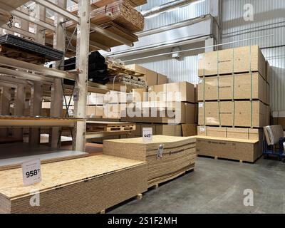 Kiew, Ukraine - 03. Januar 2025: Ein großes Indoor-Lager, in dem Stapel von Holzbrettern und -Dielen für Bauzwecke ausgestellt werden. Stockfoto