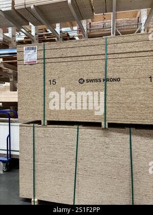 Kiew, Ukraine - 03. Januar 2025: Ordentlich gestapelte gepresste Holzbretter, die mit Gurten befestigt sind, werden in einem Lager ausgestellt. Ideal für den Bau, Stockfoto