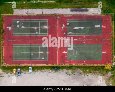 Bewachsene Plätze: Tennis- und Basketballplätze von oben gesehen. Stockfoto