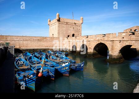 Blau lackierte traditionelle hölzerne Fischerboote vor dem Skala du Port und der Hafenbefestigung essaouira, marokko Stockfoto