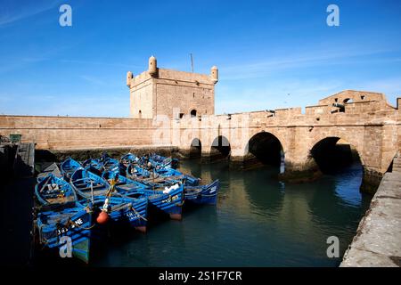 Blau lackierte traditionelle hölzerne Fischerboote vor dem Skala du Port und der Hafenbefestigung essaouira, marokko Stockfoto