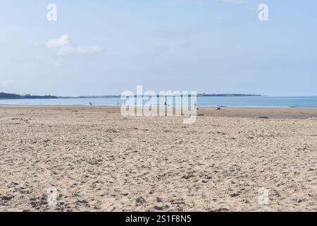 Harlech Wales - 1. August 2024; weitläufiger Blick auf den malerischen Harlech Beach mit unbedeutenden Menschen, die die Natur genießen und Sand bis zum Wasser und Horizont genießen Stockfoto